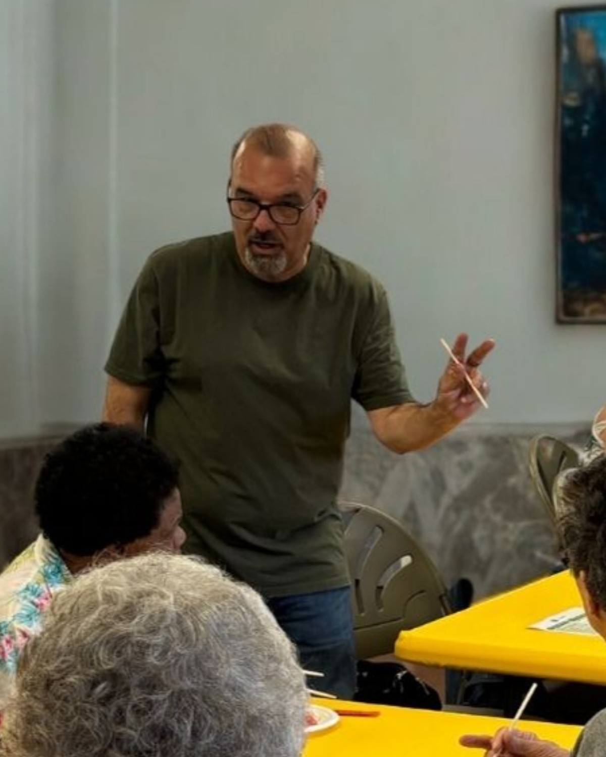 Dave Williams facilitating a hands-on workshop with participants gathered around him.
